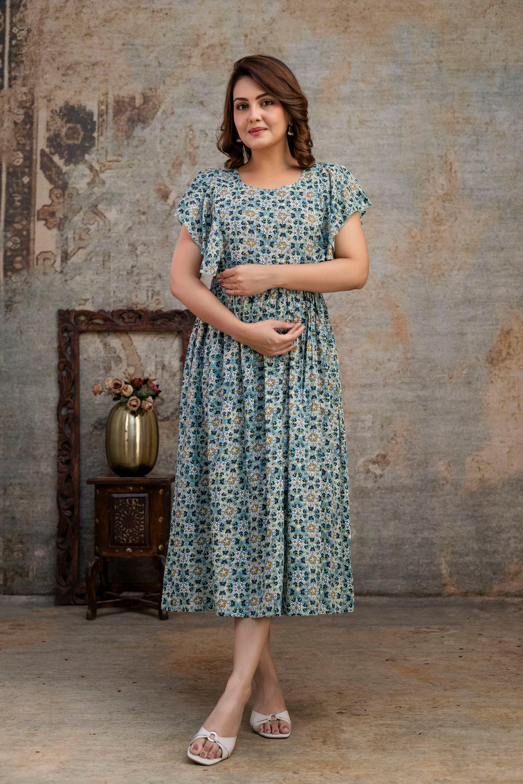 Front view of grey printed nursing dress with one hand resting at the waist