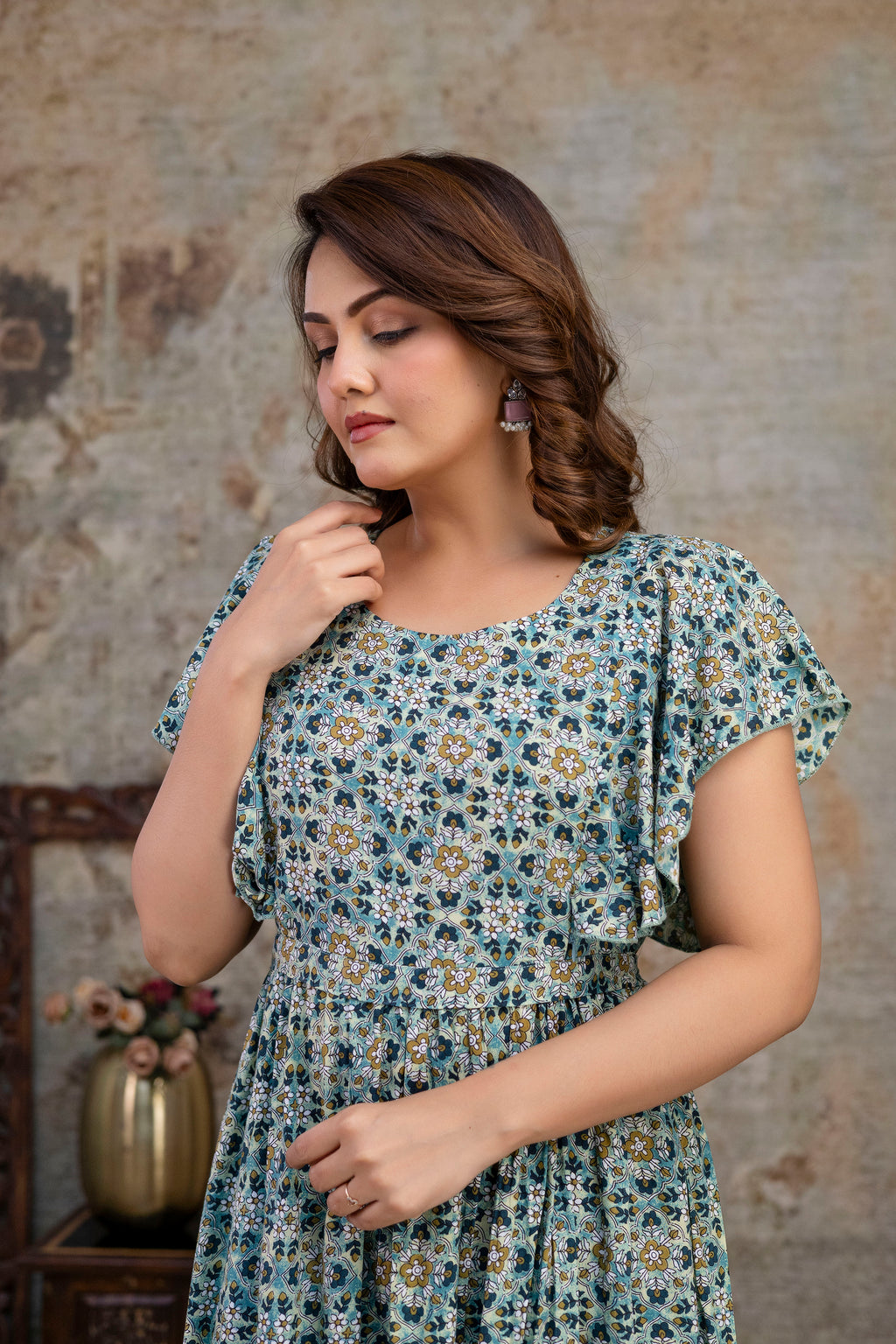 Upper-body view of grey printed dress with a round neckline and flutter sleeves