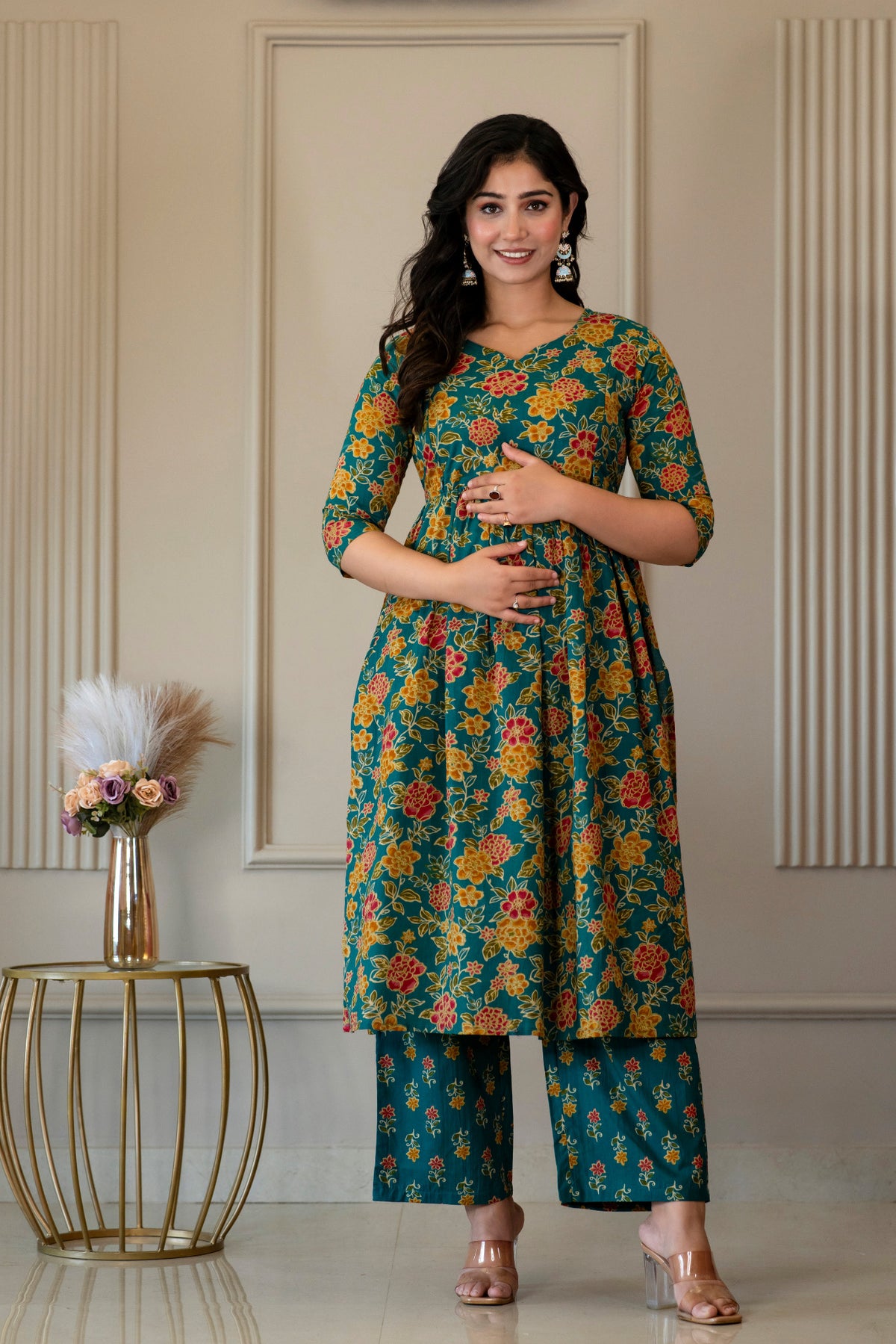 Front view of green floral kurta set with hands resting at the waist