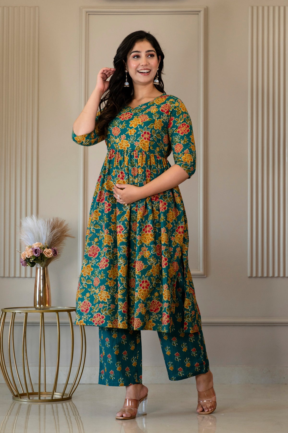Full-length view of green floral kurta set with one hand raised