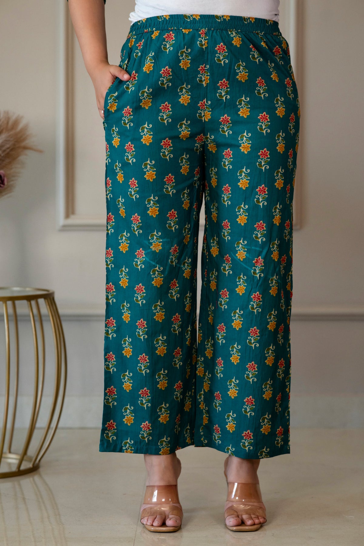 Front view of green floral palazzo trousers showing the waistband and side pocket