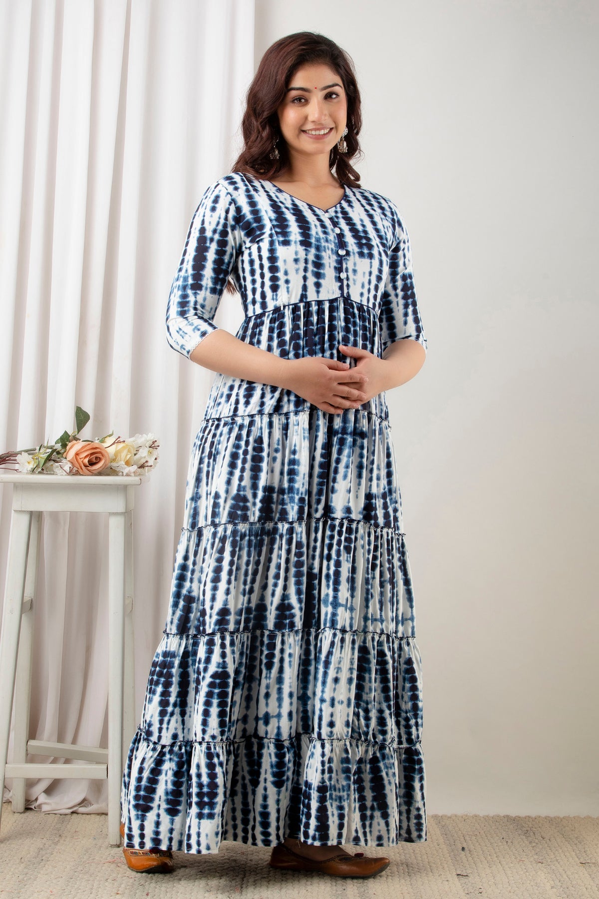 HENAL G-H380 blue and white tie-dye maternity gown: three-quarter standing view with hands together at bump.