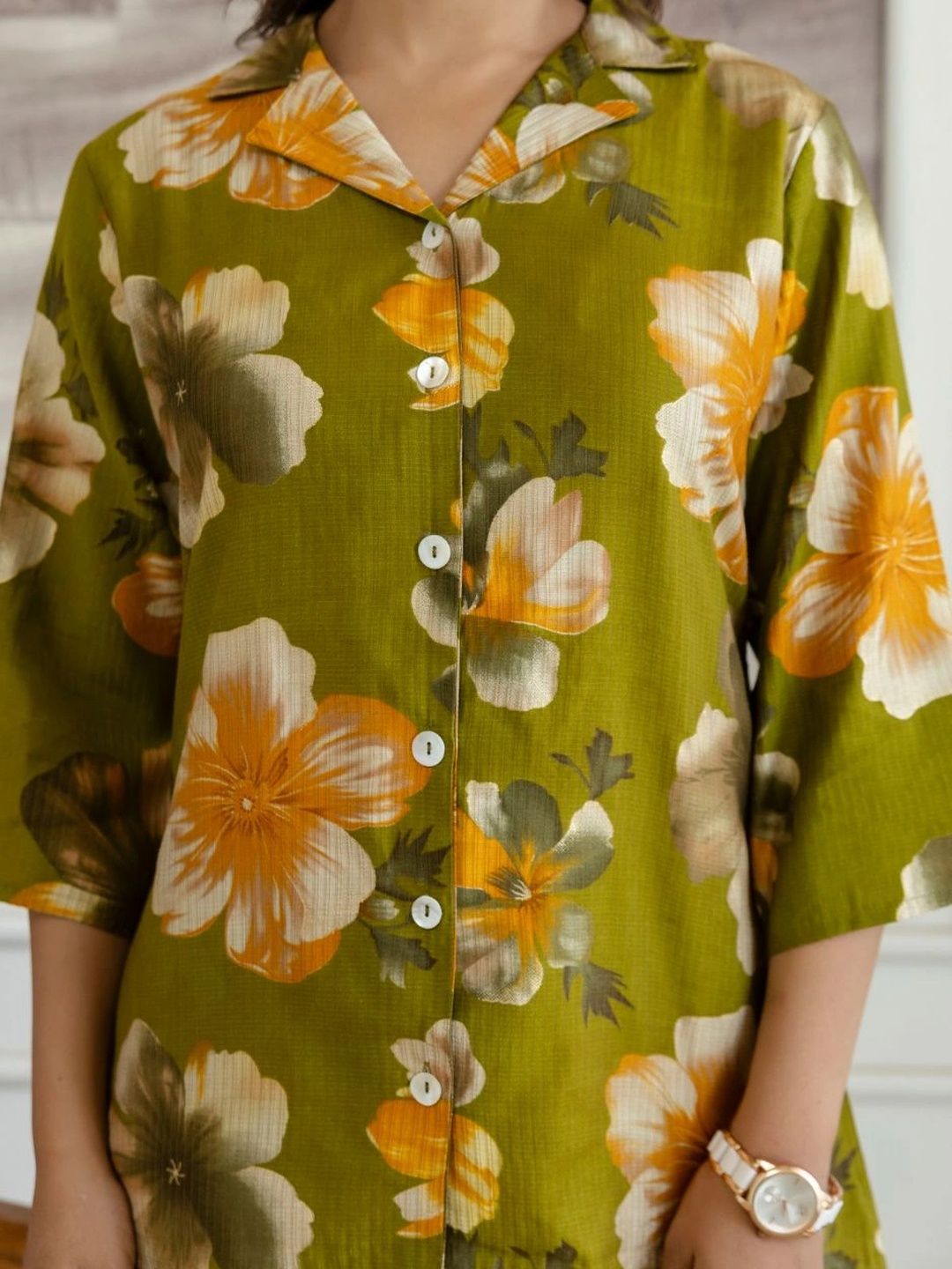 HENAL H2517 Green co-ord set. Close-up of collar, white buttons and large floral print.