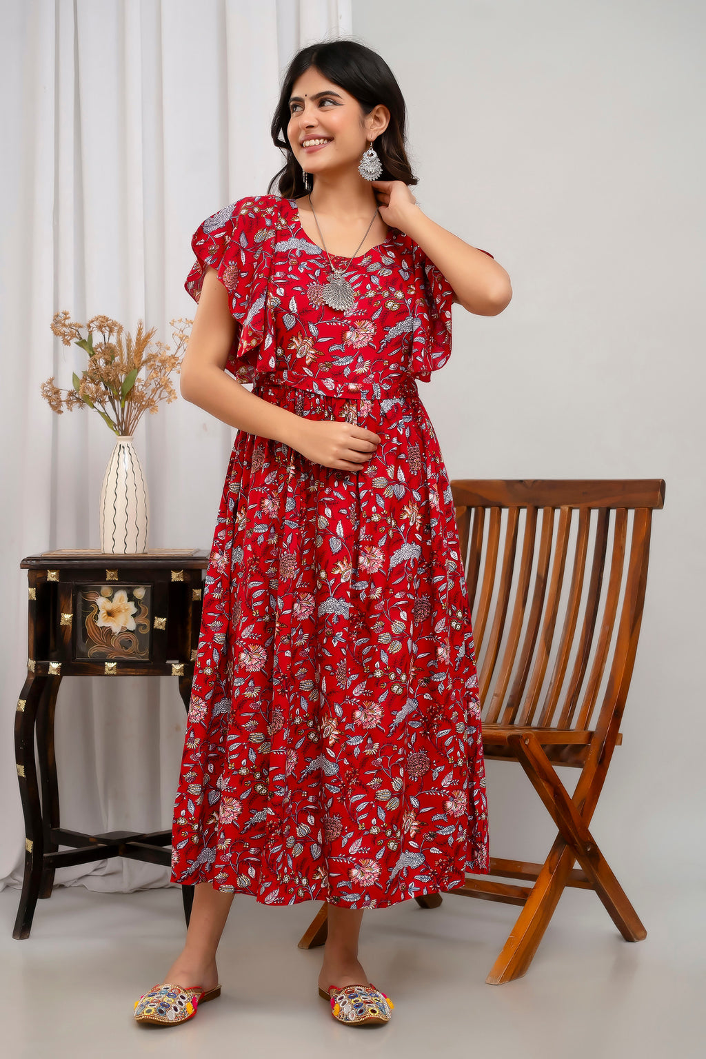 HENAL H391 Red floral maternity kurti, front standing view with one hand at the neck and the full skirt visible.