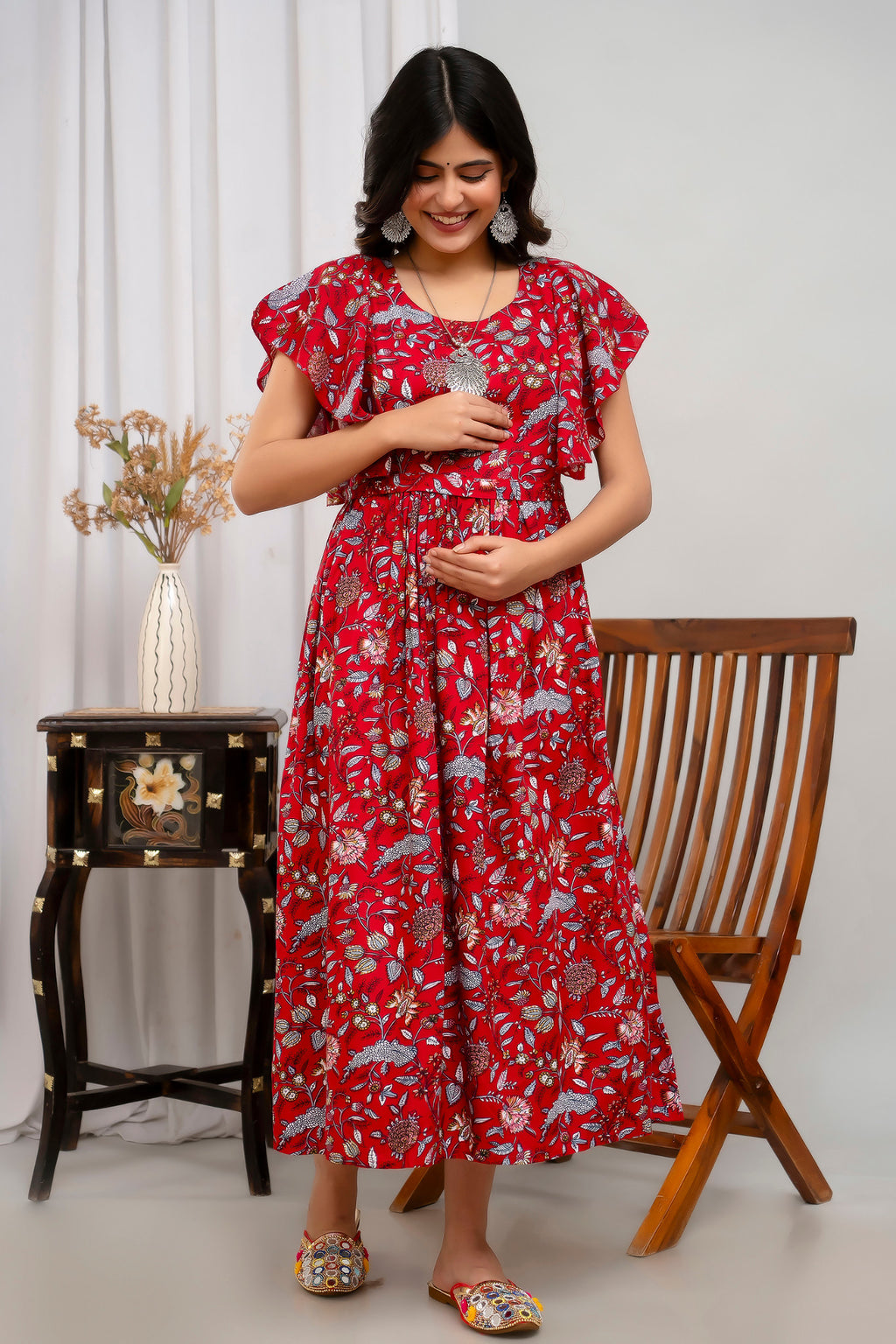 HENAL H391 Red floral maternity kurti, full-length front view with both hands resting over the midsection.