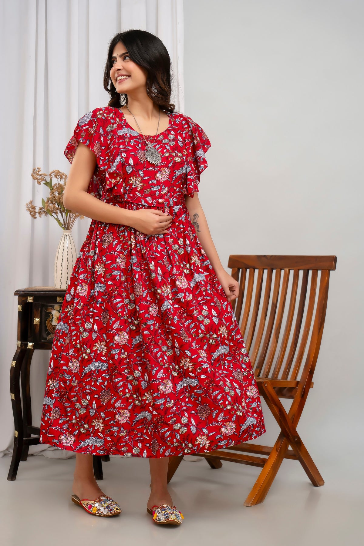 HENAL H391 Red floral maternity kurti, angled standing view with the flared skirt held out at one side.