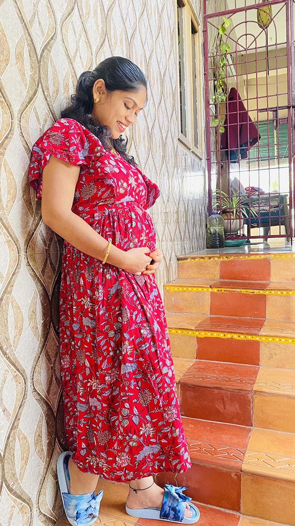 Customer wearing a red floral dress beside tiled steps